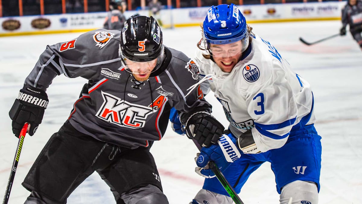 Riley McCourt battles with Willie Corrin for a loose puck